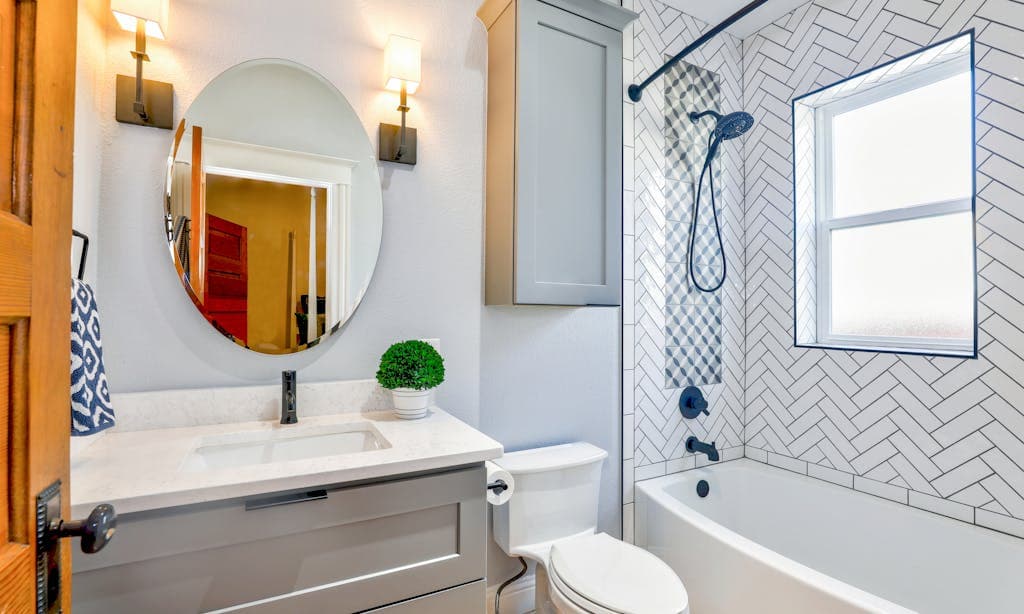Badkamer met visgraat wandtegels en een decoratieve accentstrook
